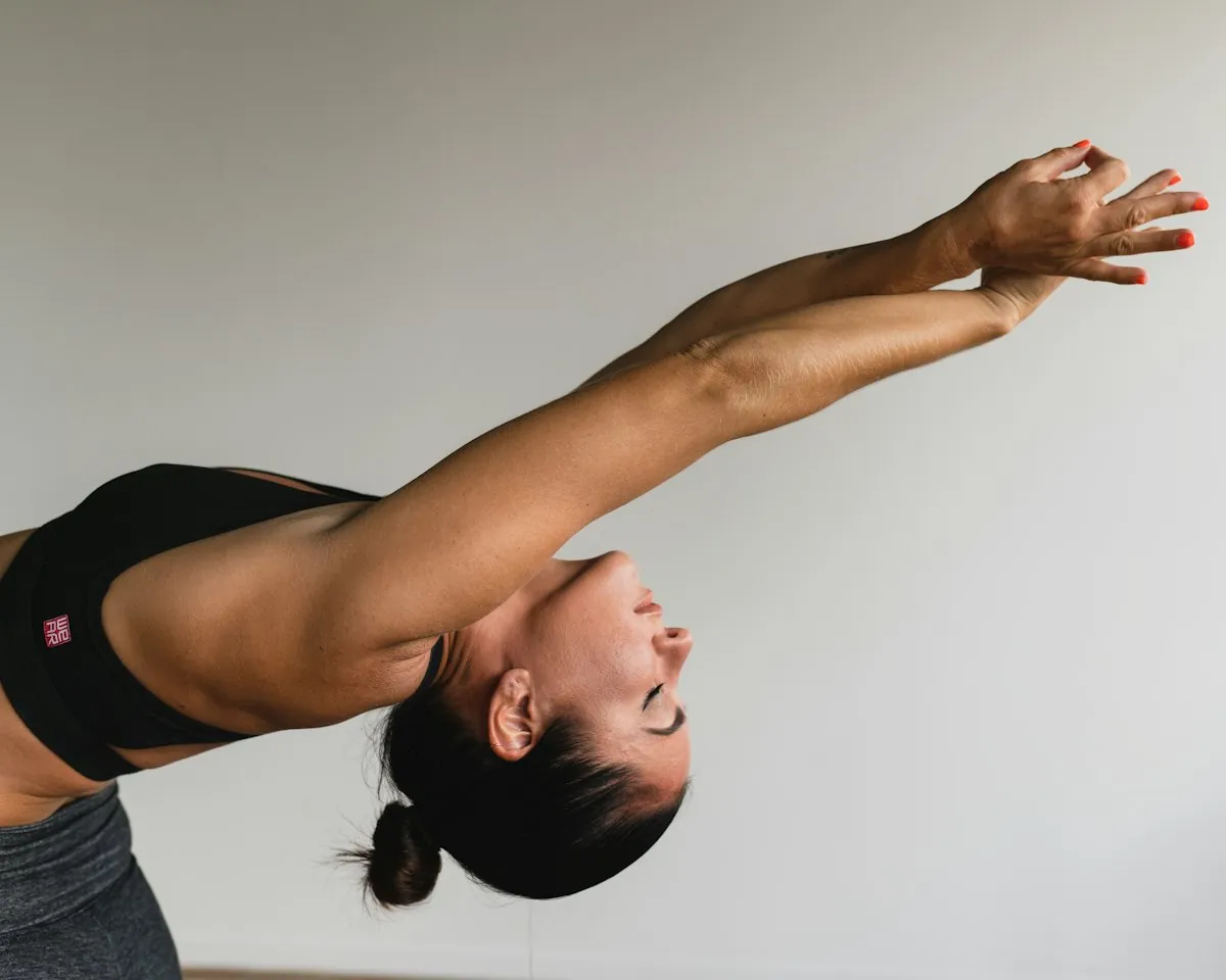 A woman stretching her arms overhead in soft light